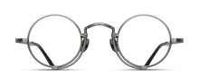 Load image into Gallery viewer, Optical glasses frames are pictured, displaying a frontal view. The glasses feature a round lens shape outlined in antique silver and a M + N engraving along the rim and temple.