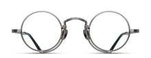 Load image into Gallery viewer, Optical glasses frames are pictured, displaying a frontal view. The glasses feature a round lens shape outlined in antique silver and a M + N engraving along the rim and temple. 
