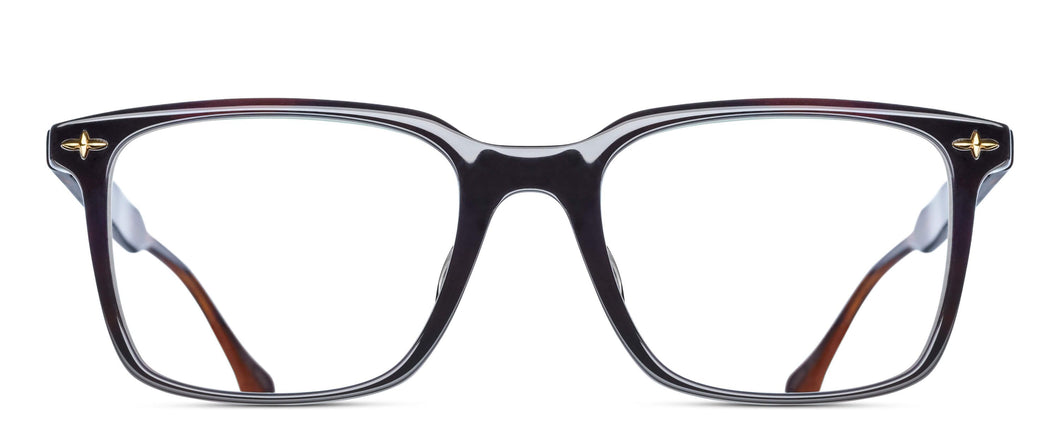 An acetate, square-shaped glasses frame is pictured. The frame is dark green color and features a gold filigree rivets in each of the frame's corners.